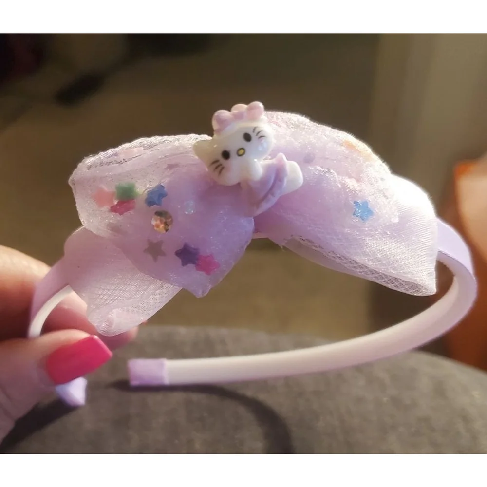 Four Hello Kitty headbands with small figurine